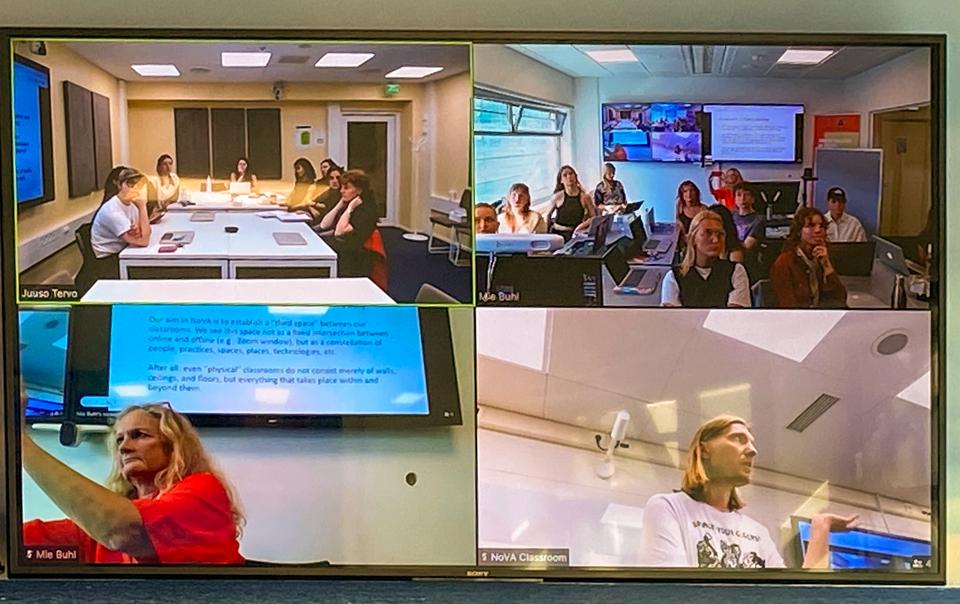 A Large screen show scenes from teaching simultaneously at Aalto University and Aalborg University.
