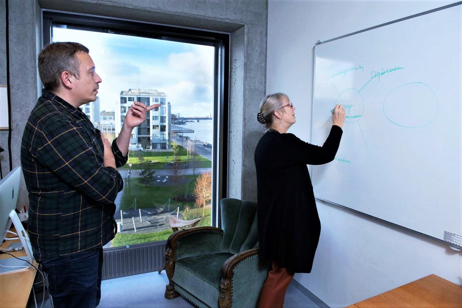 Thomas Ryberg and Anette Kolmos are working on a white board.